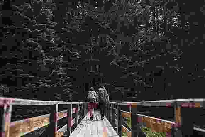 Hikers Crossing A Wooden Bridge Over A Crystal Clear Stream Surrounded By Lush Vegetation Explorer S Guide 50 Best Hikes In New England: Day Hikes From The Forested Lowlands To The White Mountains Green Mountains And More (Explorer S 50 Hikes)